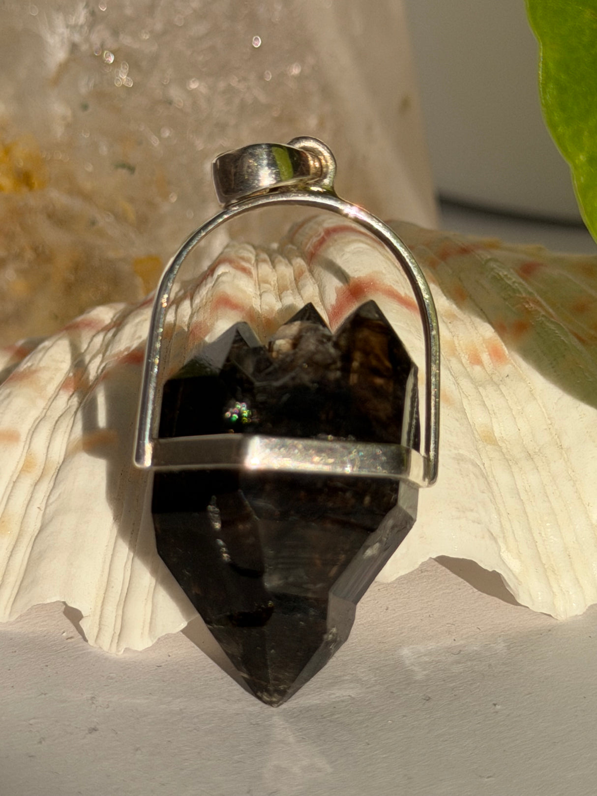 Crystal pendant with silver setting on a shell