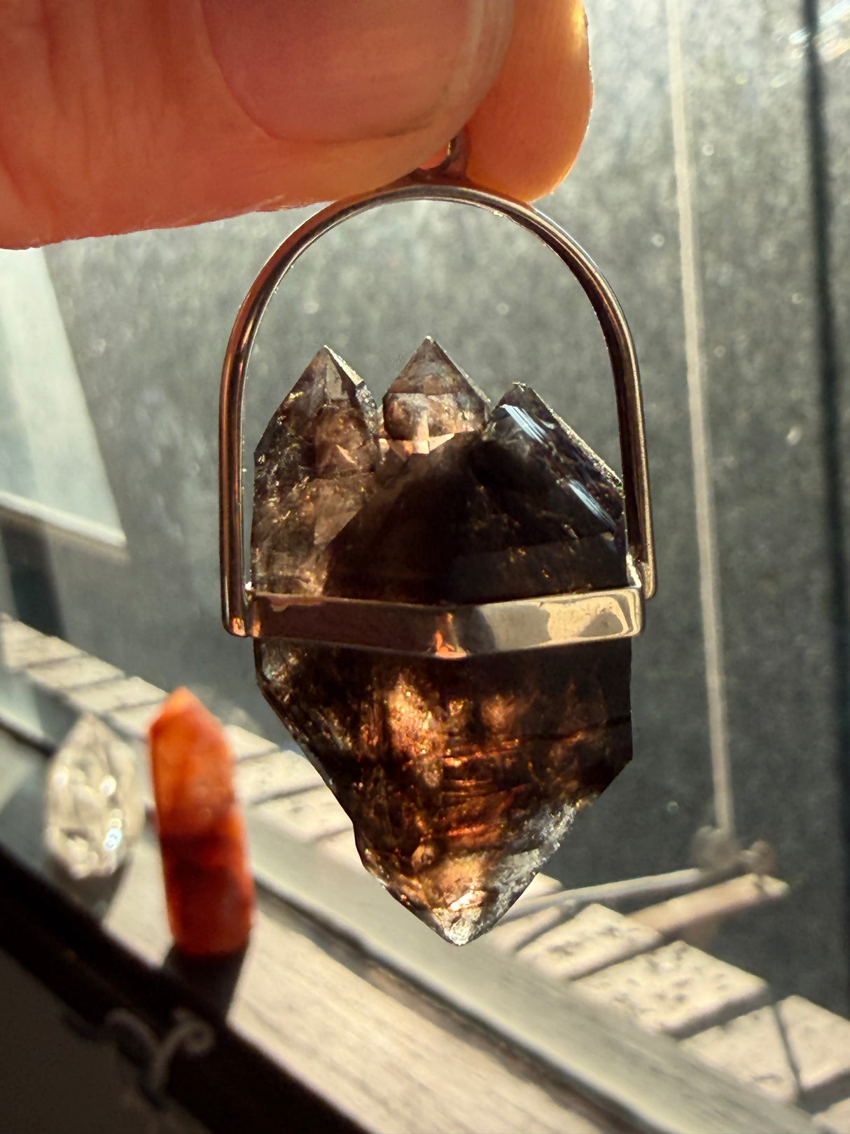 Mooralla Smoky Quartz pendant held up to the sunlight