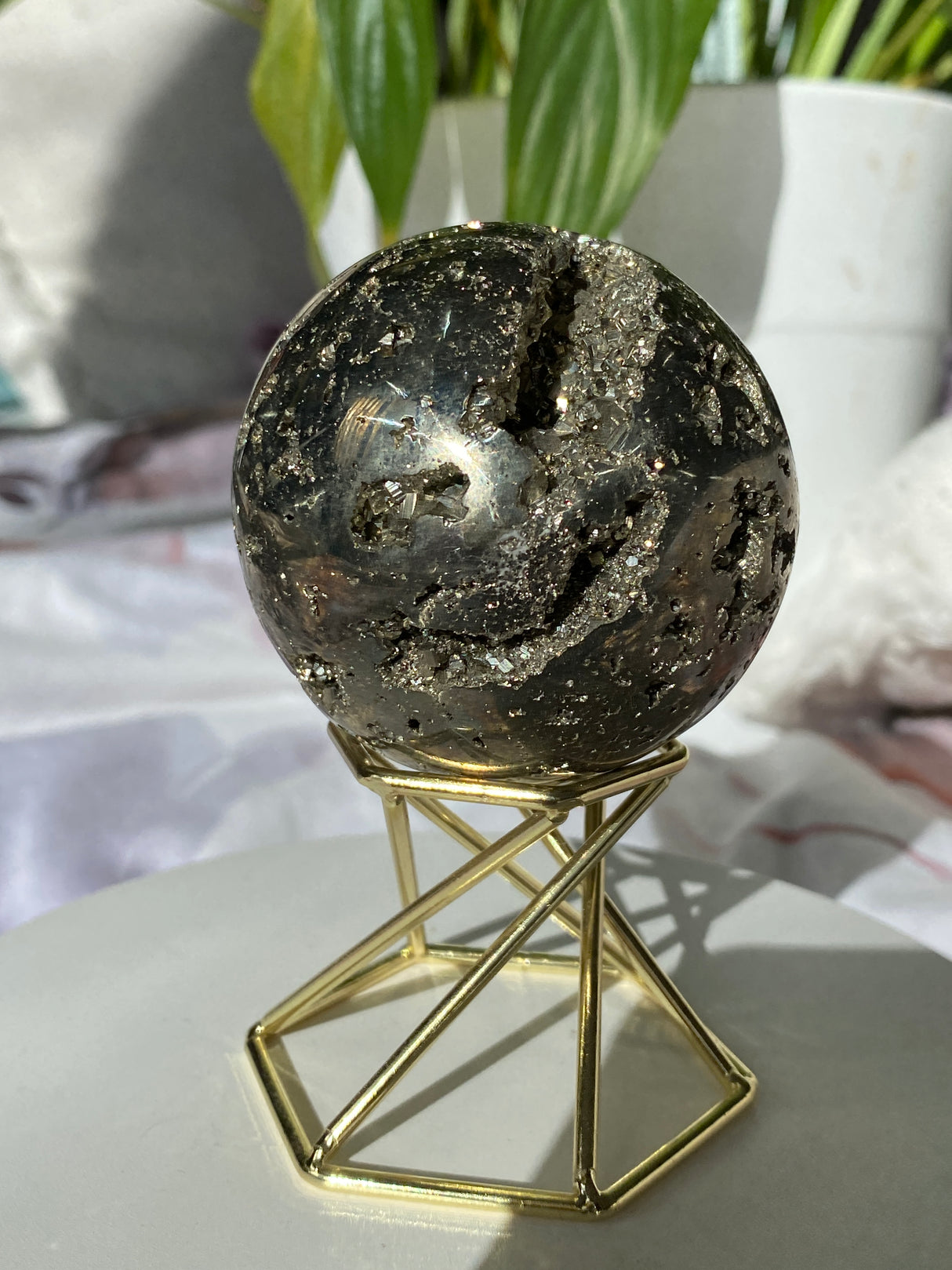 Golden pyrite sphere on a gold brass hexagonal twist stand
