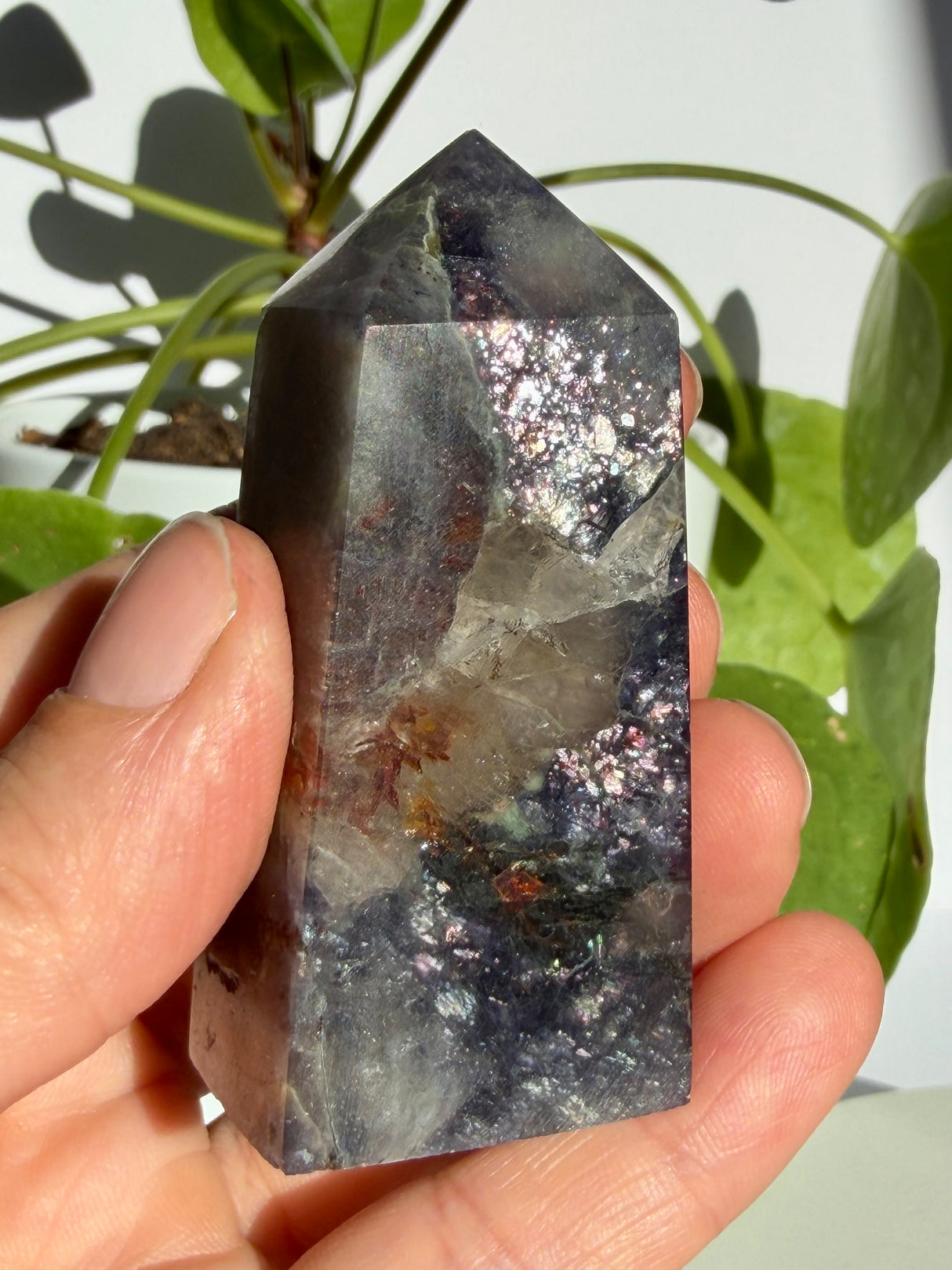 Sunstone in iolite crystal point showing a translucent central pocket with rust-red mineral inclusions running through it