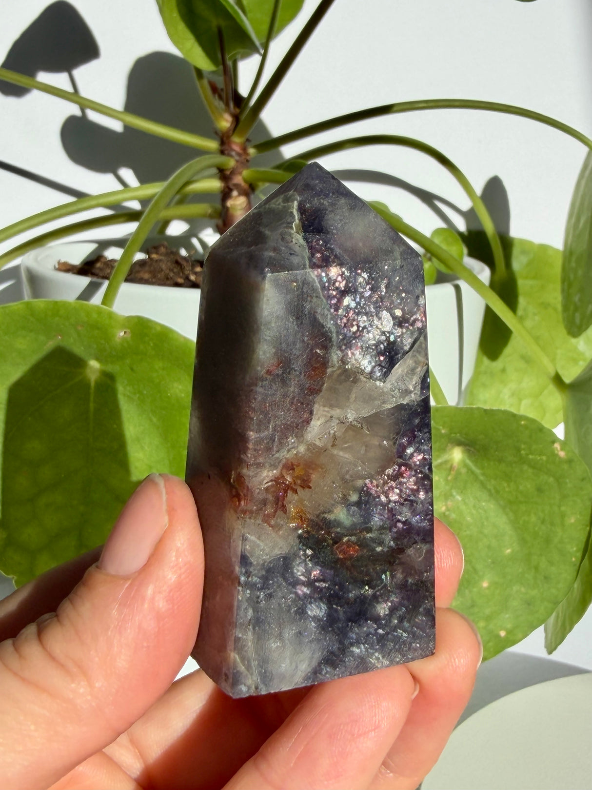 Sunstone in iolite point with a clear notch at the apex and a prominent rust-brown inclusion cluster through the centre