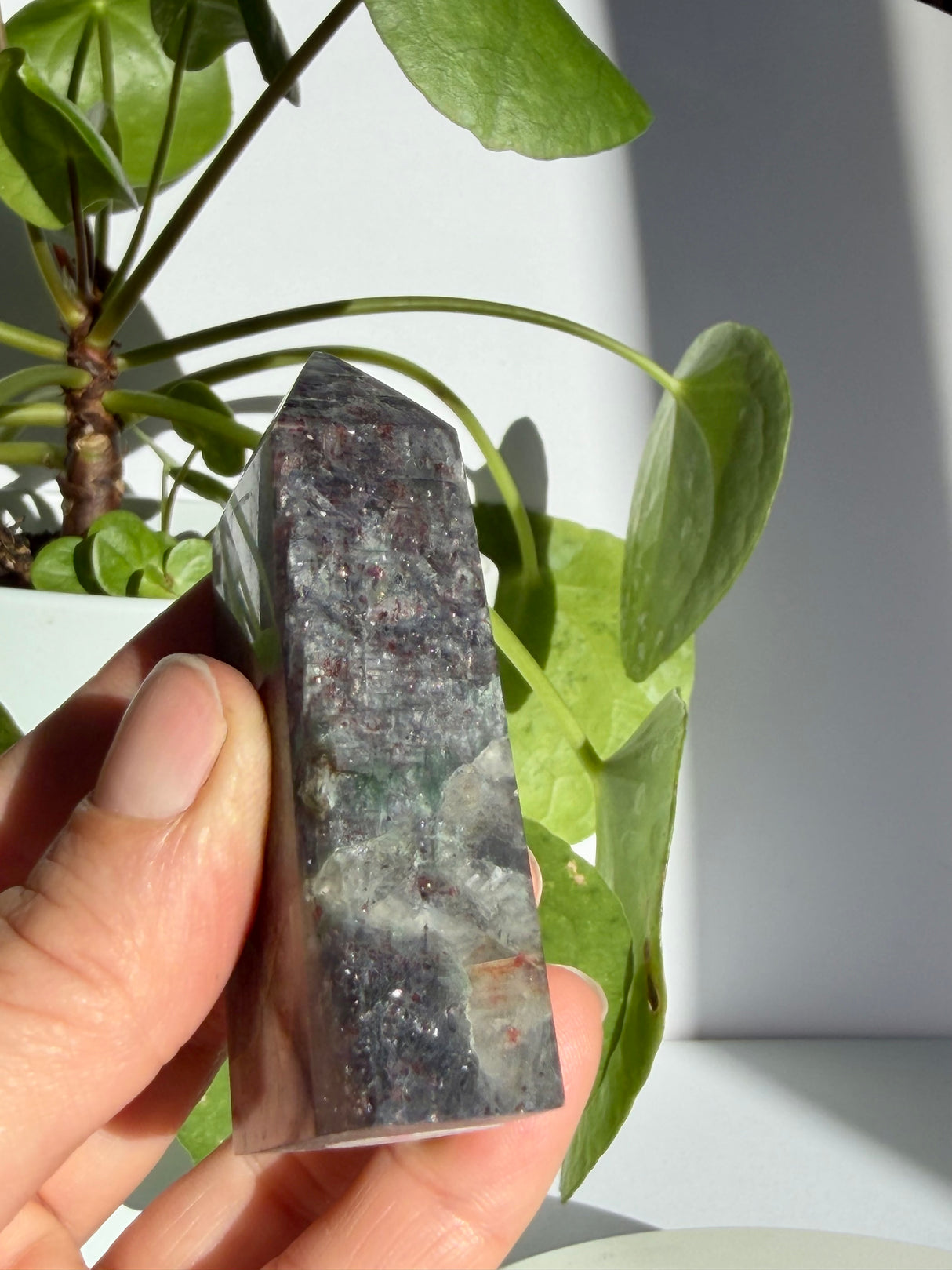 Close view of a sunstone in iolite point highlighting dense coppery sparkle above a clear quartz-toned base