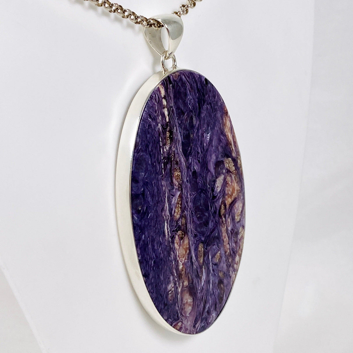 Purple Charoite large oval pendant in sterling silver sitting on a chain