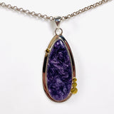 Purple Charoite tear drop pendant with brass detailing  in sterling silver on a chain