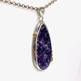 Purple Charoite tear drop pendant with brass detailing  in sterling silver on a chian