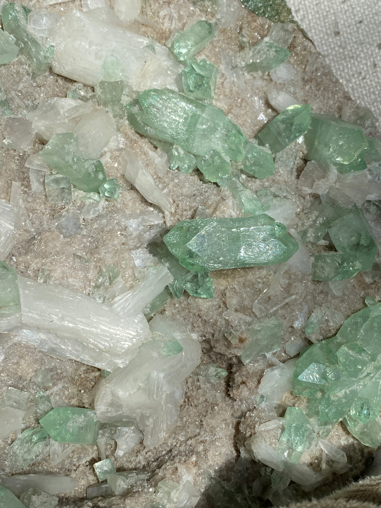Close-up of green Apophyllite crystals with white stilbite on heulandite