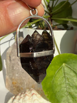 Mooralla Smokey Quartz crystal set into a silver pendant with a nature background