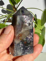 Sunstone in iolite crystal point showing a translucent central pocket with rust-red mineral inclusions running through it