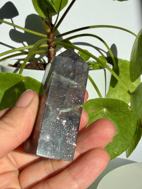 Sunstone in iolite point with a fine diagonal fracture line near the top and dense sparkle through the lower half