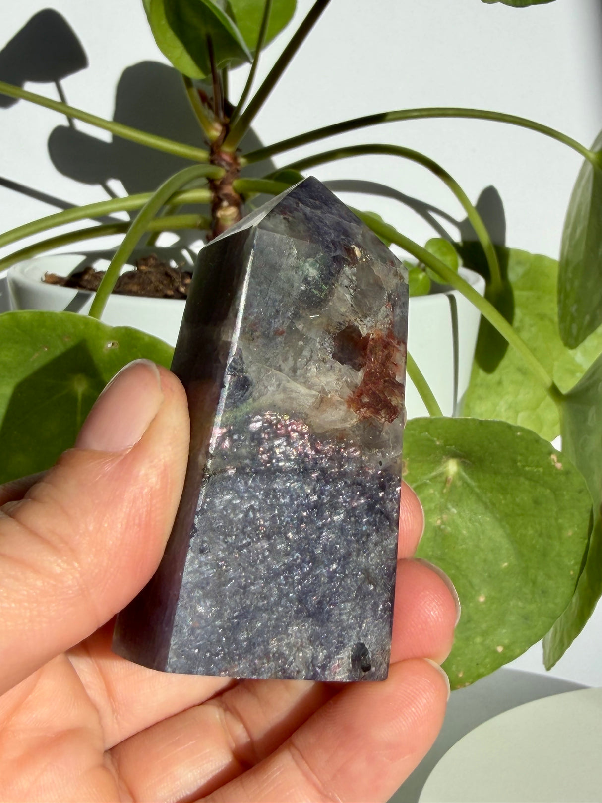 Close view of a sunstone in iolite point highlighting silver-pink aventurescence sparkle across its lower section