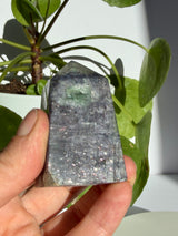 Sunstone in iolite point photographed near the apex, highlighting a pale translucent pocket with a green fleck