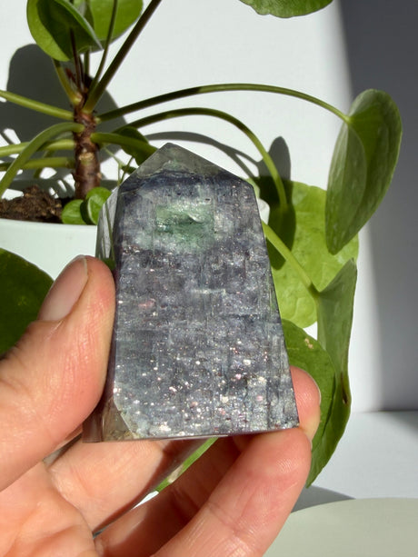 Sunstone in iolite point photographed near the apex, highlighting a pale translucent pocket with a green fleck