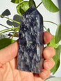 Sunstone in iolite crystal point with a dense, evenly mottled grey-violet texture and a fine natural fracture line