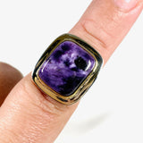 Purple Charoite rectangular ring with brass detailing in sterling silver sitting on a hand