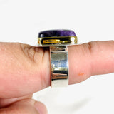 Purple Charoite rectangular ring with brass detailing in sterling silver sitting on a hand