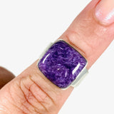 Purple Charoite square ring in sterling silver sitting on a hand