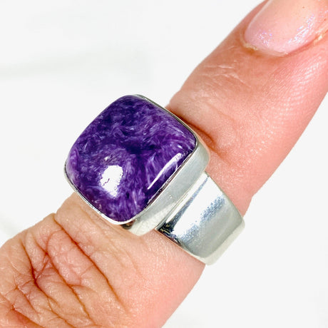 Purple Charoite square ring in sterling silver sitting on a hand