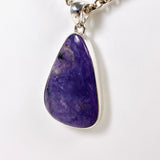 Purple Charoite tear drop pendant in sterling silver sitting on a chain