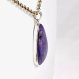 Purple Charoite tear drop pendant in sterling silver sitting on a chain