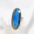 Blue iridescent Labradorite faceted gemstone ring set in silver on a clear quartz crystal