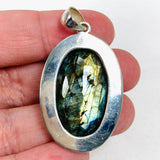 Blue iridescent Labradorite faceted gemstone and silver pendant in hand