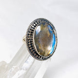 Blue iridescent Labradorite faceted gemstone ring set in silver on a clear quartz crystal