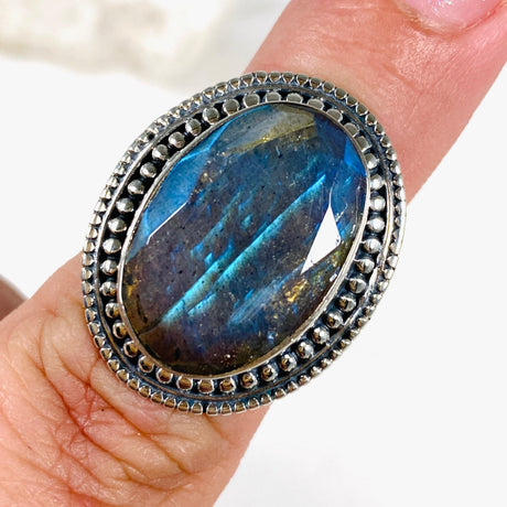 Blue iridescent Labradorite faceted gemstone ring set in silver on a finger