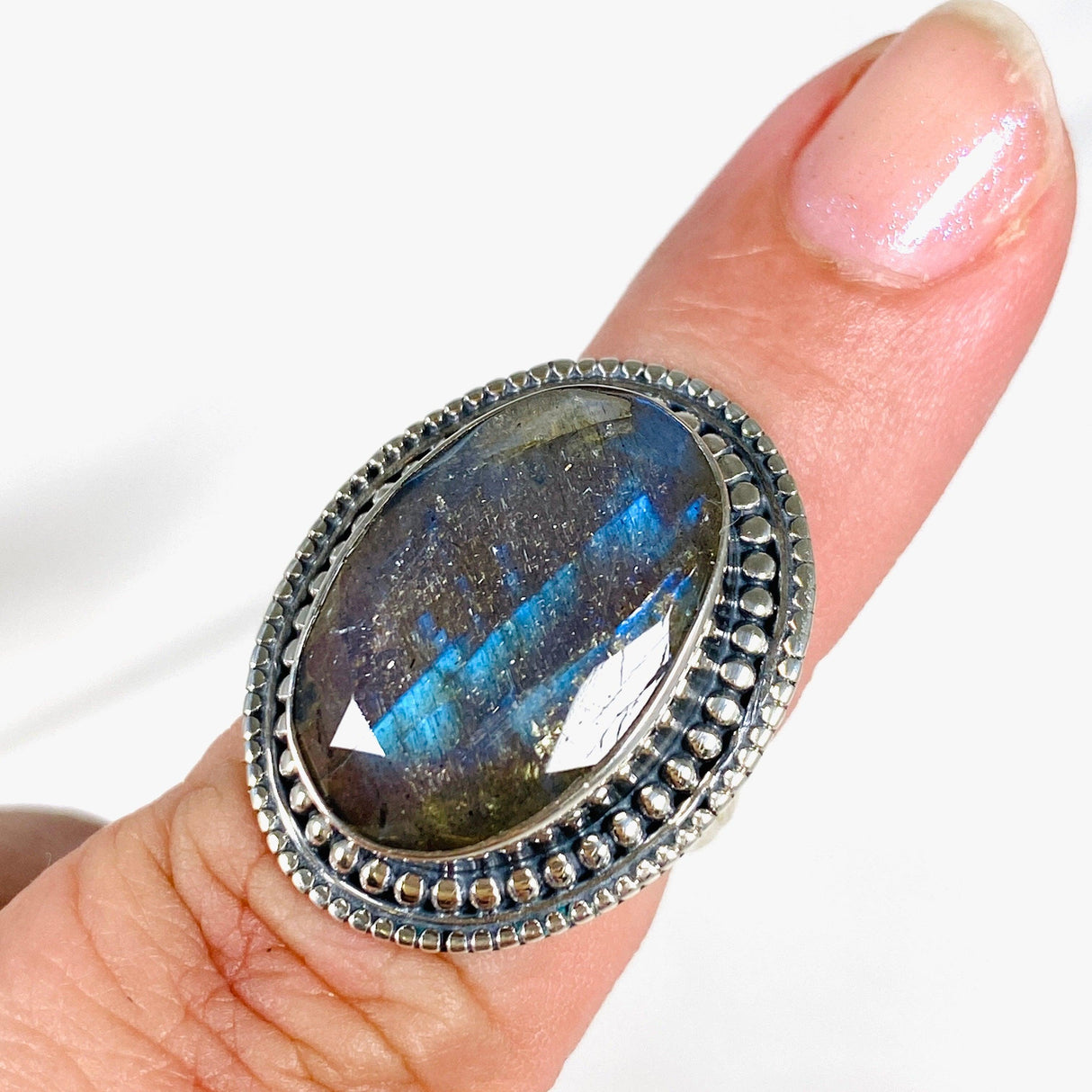 Blue iridescent Labradorite faceted gemstone ring set in silver on a finger