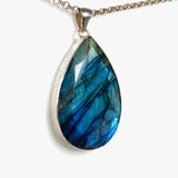 Blue iridescent Labradorite faceted gemstone pendant set in silver on a belcher chain side on angle