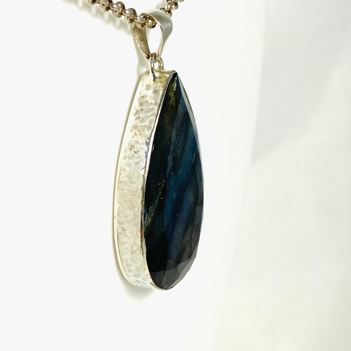 Blue iridescent Labradorite faceted gemstone pendant set in silver on a belcher chain side on angle