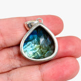Blue iridescent Labradorite faceted gemstone and silver pendant on a hand