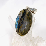 Blue iridescent Labradorite faceted gemstone and silver pendant on a clear quartz crystal