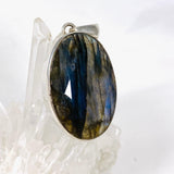 Blue iridescent Labradorite faceted gemstone and silver pendant on a clear quartz crystal