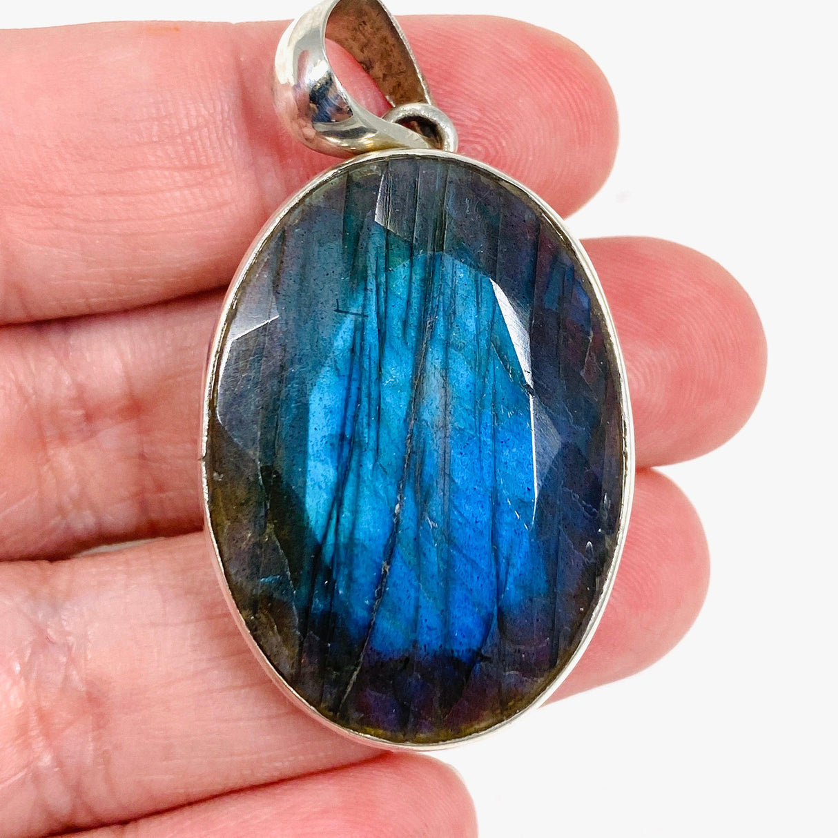 Blue iridescent Labradorite faceted gemstone and silver pendant in a handl