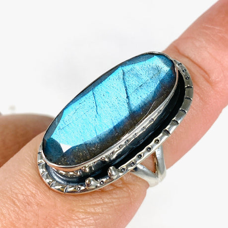 Blue iridescent Labradorite faceted gemstone ring set in silver on a finger