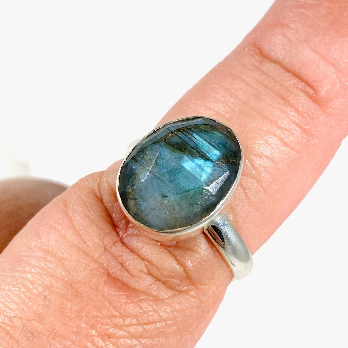  Blue iridescent Labradorite faceted gemstone and silver ring on a finger