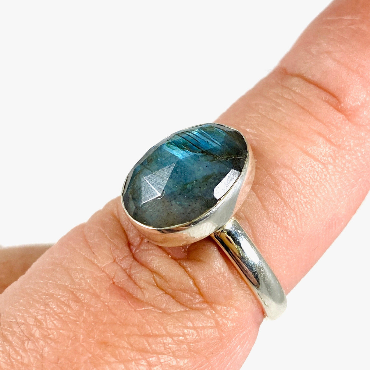  Blue iridescent Labradorite faceted gemstone and silver ring on a finger