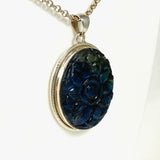 Oval shaped blue and gold flash labradorite flower carving pendant set in silver shown on a silver belcher chain