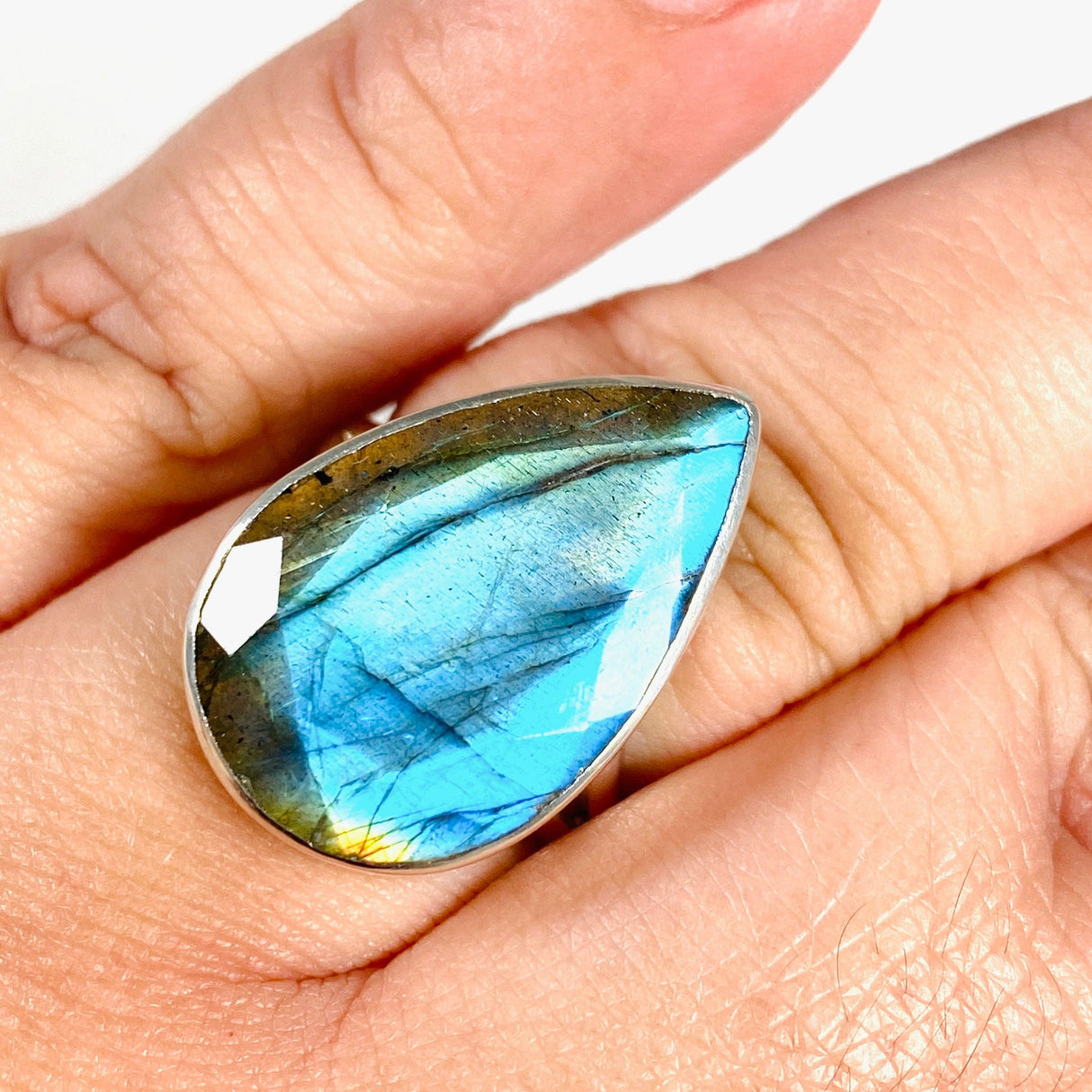  Blue iridescent Labradorite faceted gemstone and silver ring on a hand