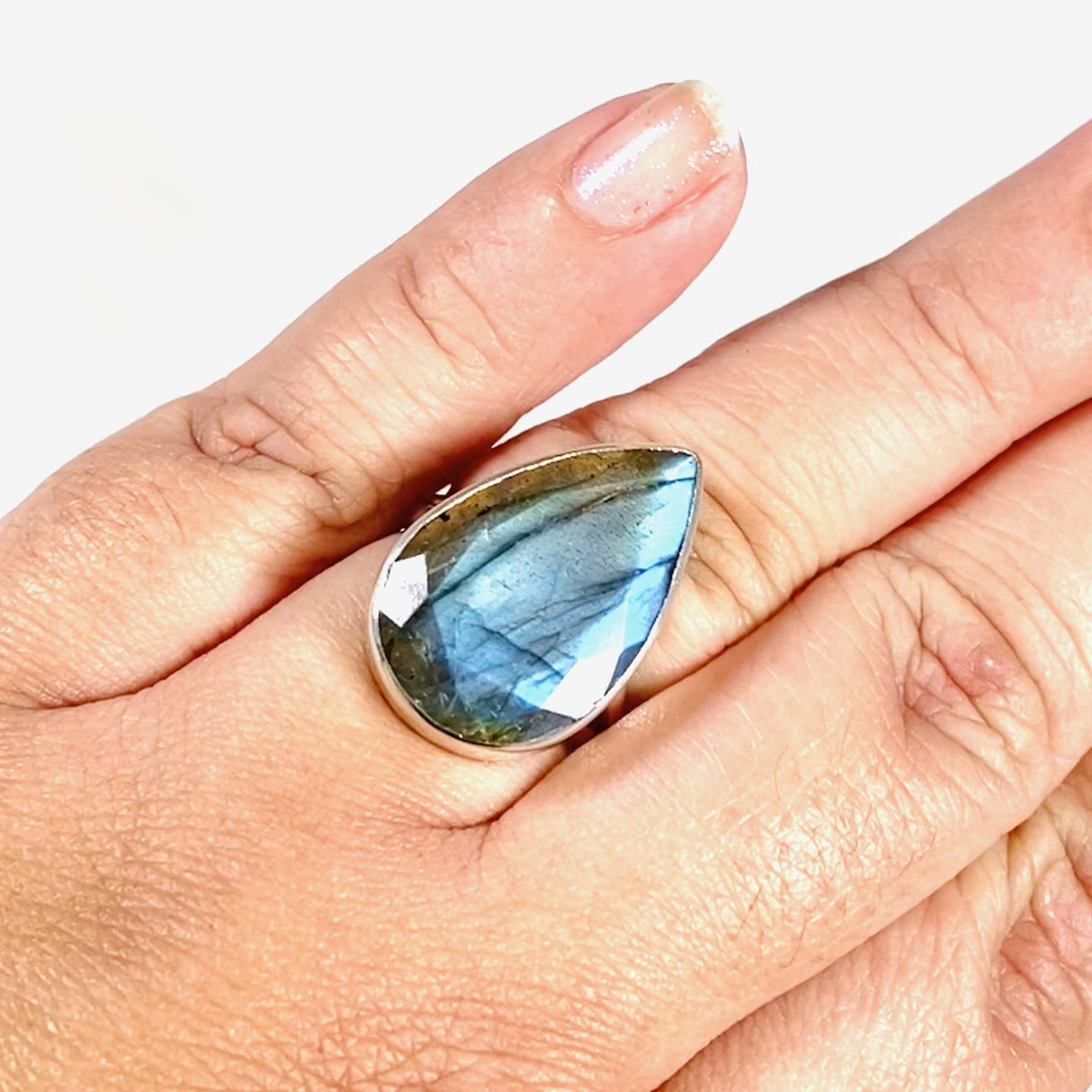  Blue iridescent Labradorite faceted gemstone and silver ring on a hand