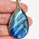 Blue iridescent Labradorite faceted gemstone pendant set in silver shown in a hand