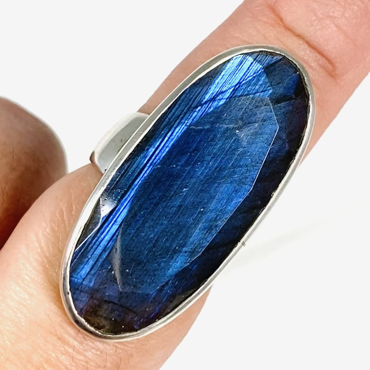 Blue iridescent Labradorite faceted gemstone ring set in silver on a finger