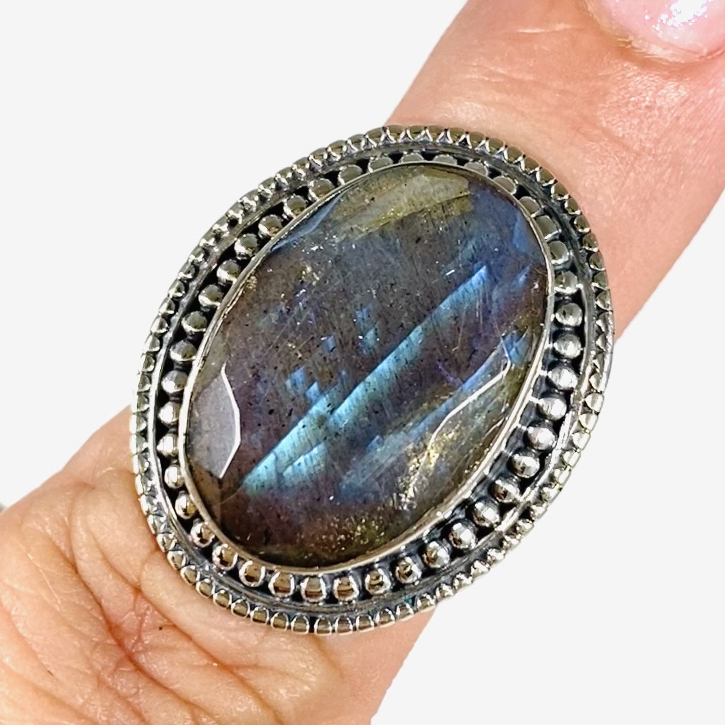 Blue iridescent Labradorite faceted gemstone ring set in silver on a finger