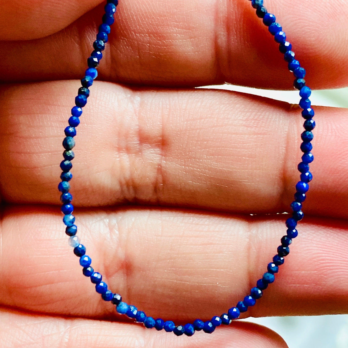 Lapis Lazuli fine 1.5mm micro-bead gemstone necklace  close upin hand 